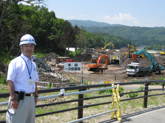 震災がれき処分場の前に立つ篠原さんの写真