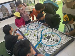 模型で天神と博多の将来の街並みを見る様子