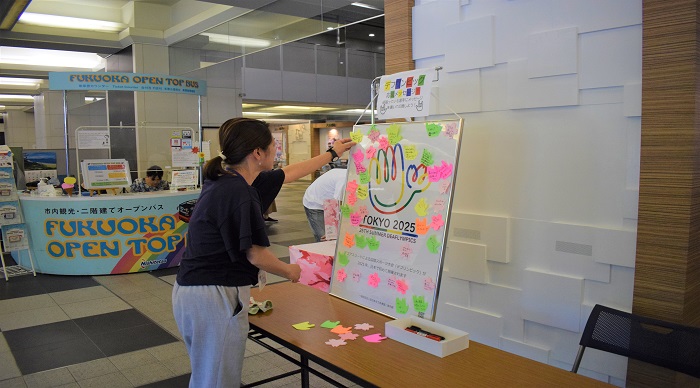 ボードへ応援メッセージを記入した付箋を貼る人