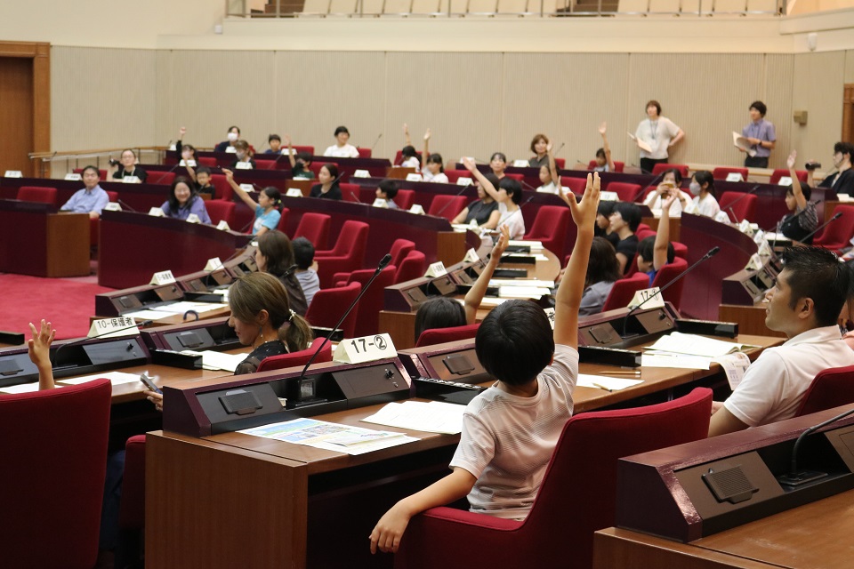 挙手により採決している写真