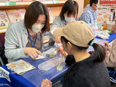 牛乳パックに塗る色を選ぶ子どもの写真