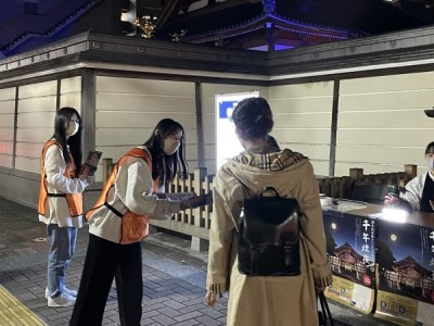 受付の前で、スタッフが来場者にイベントの説明をしている写真