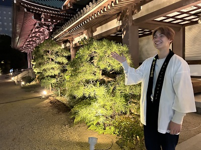 通路の脇に立った白い法被のスタッフが順路を指している写真