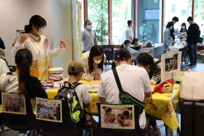 親子が学生と一緒におもちゃを作っている写真