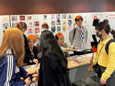 学生が自分の作成した缶バッジを来場者に紹介している写真