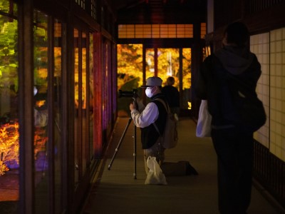 学生が三脚を使って縁側の風景を撮影している写真