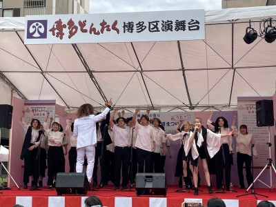 白いシャツと黒いズボンで衣装を揃えた大人数グループがゴスペルを披露している写真