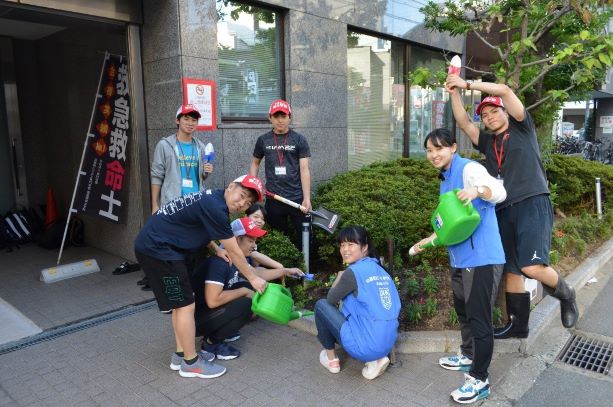 学生がじょうろやスコップを片手に、花壇を作っている様子