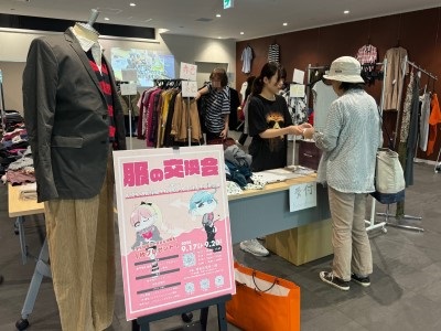 学生が、服を持ってきた来場者に服との思い出話を聞きながら受付をしている写真