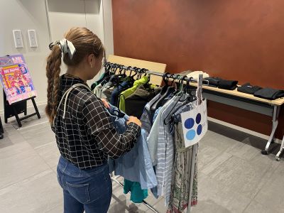 ラックに掛けられた服を選んでいる写真