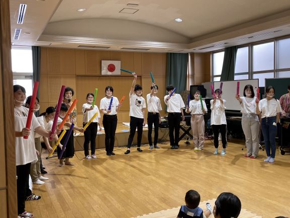 学生がカラフルなパイプ状の楽器で演奏している写真