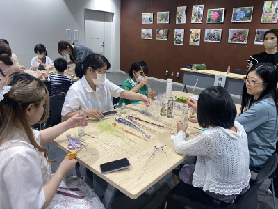 テーブルに並べられたドライフラワーから好きなものを選んでいる写真