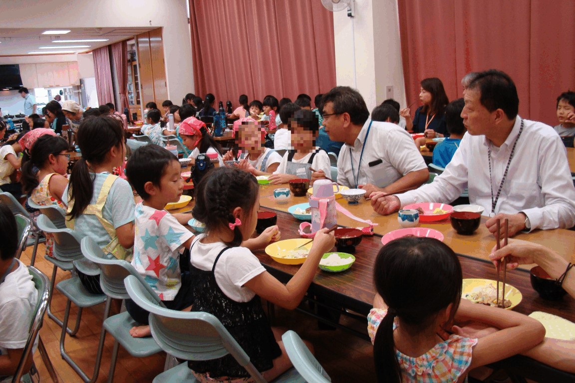 区長と楽しく食事する子どもたち