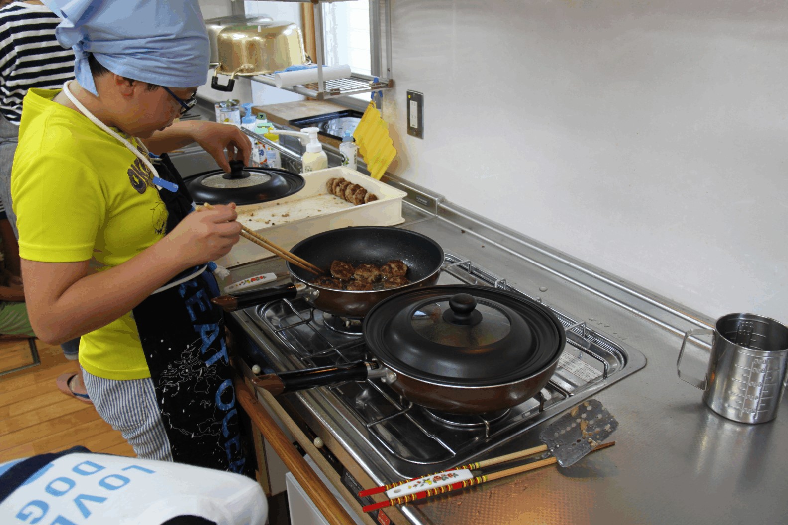 ハンバーグをフライパンで焼く男の子の写真