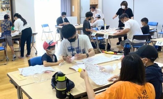 大学生が小学生のロケット作りを手伝う様子