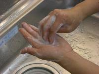 手のひらで指先をこすっている写真