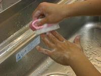 爪ブラシで爪の間の汚れを落としている写真