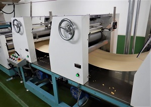 機械で板状になった生地を伸ばしている写真