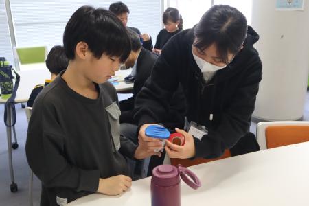 学生サポーターが参加者と空気砲を制作している様子