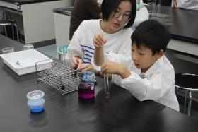 参加者の子どもが色素溶液を試験管へ移し替えている様子