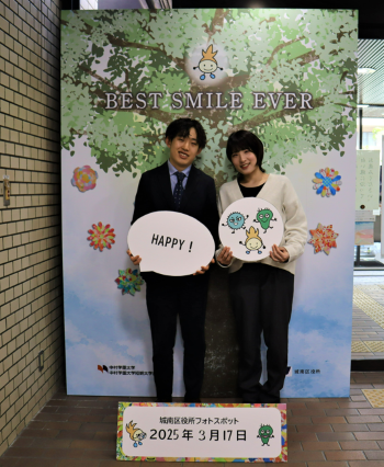 オリジナル記念撮影ボードの前で写真を撮っている様子