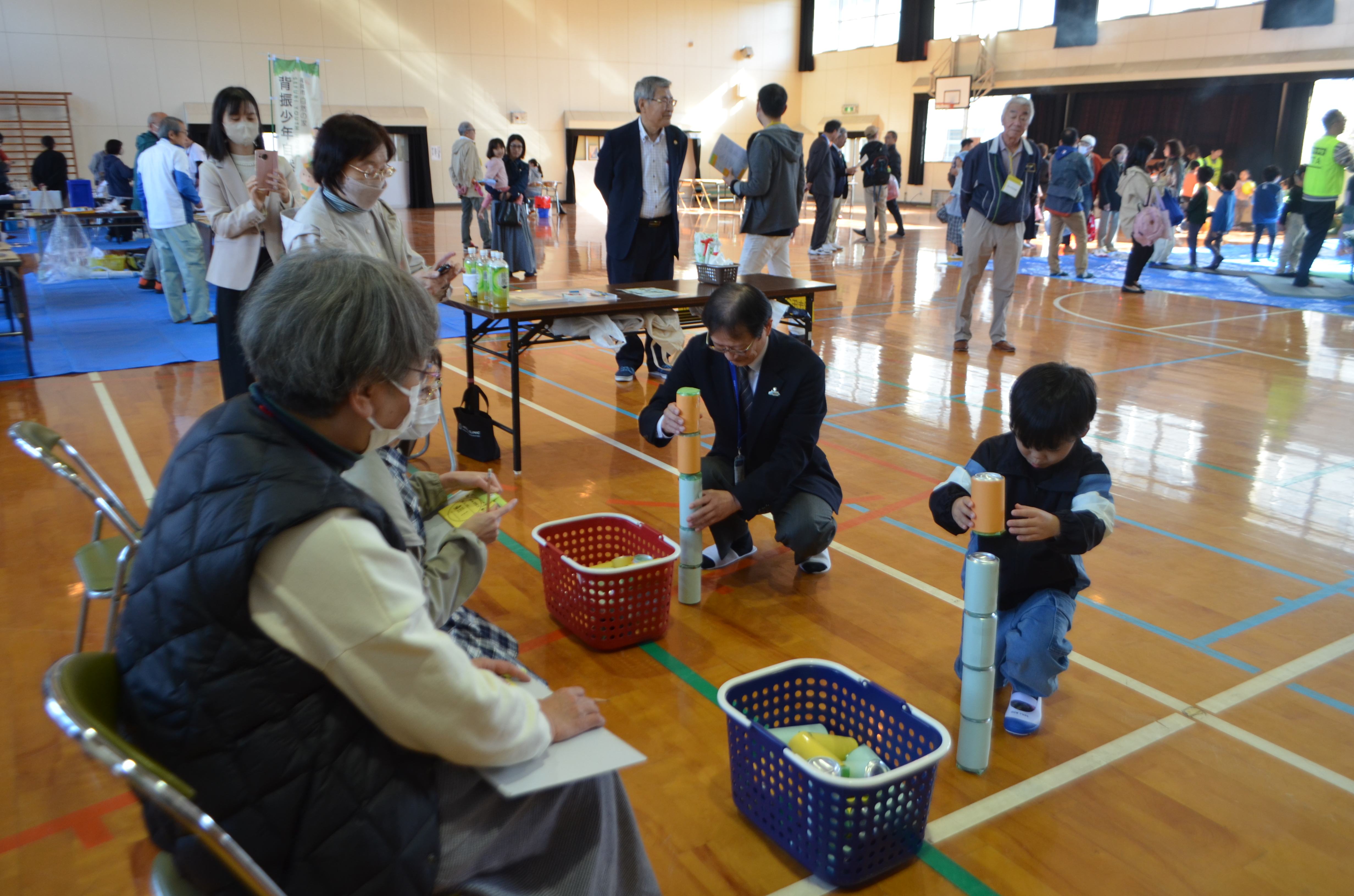 空き缶積みで子どもと対戦する区長の写真
