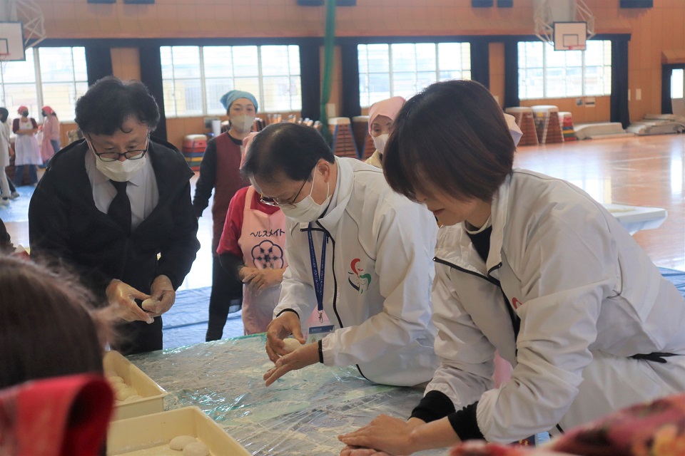 校区食生活改善推進員の皆さんにコツを教わりながら餅を丸める区長