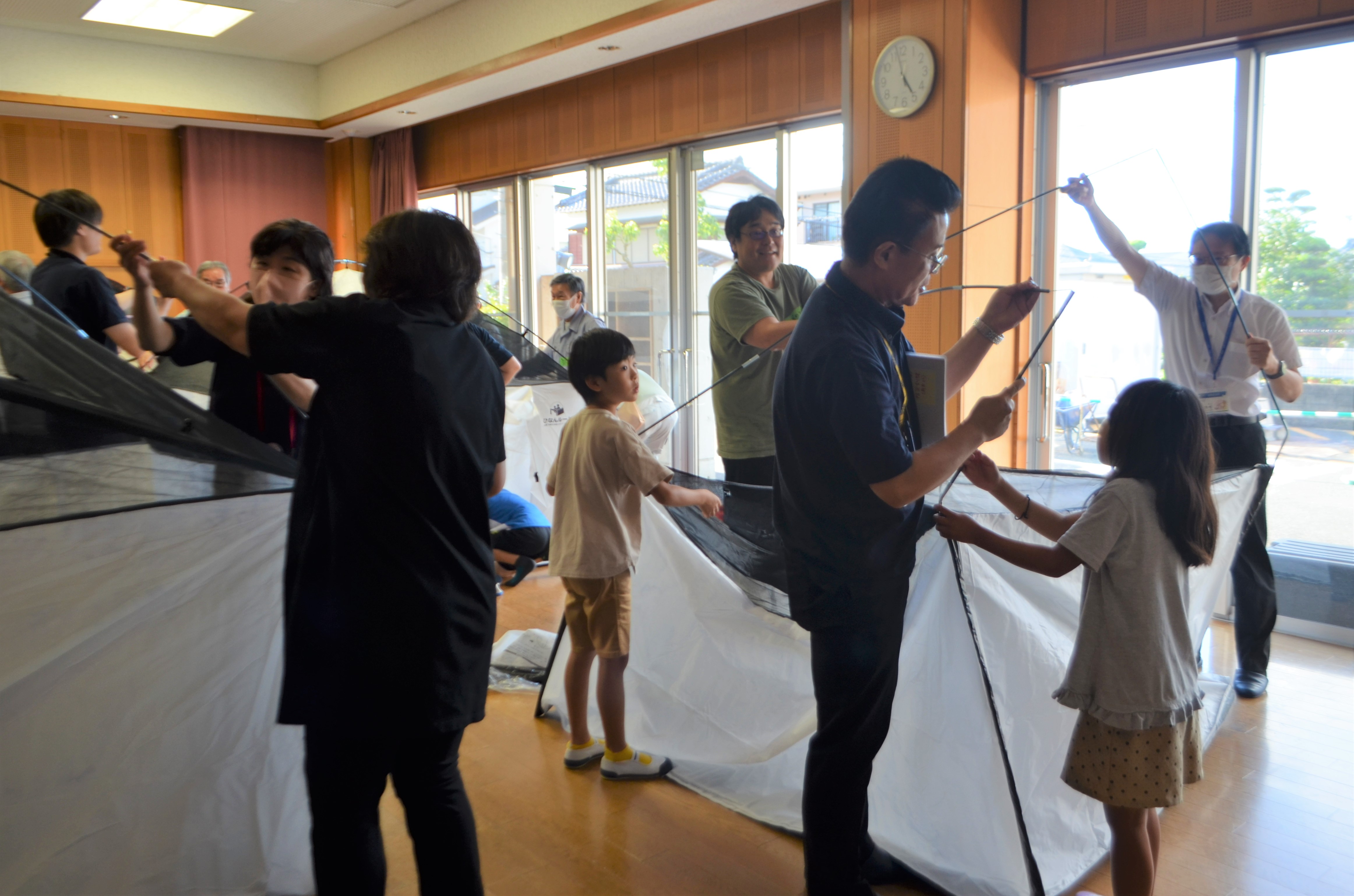 区長が住民の皆さんと一緒にテントを設営している写真