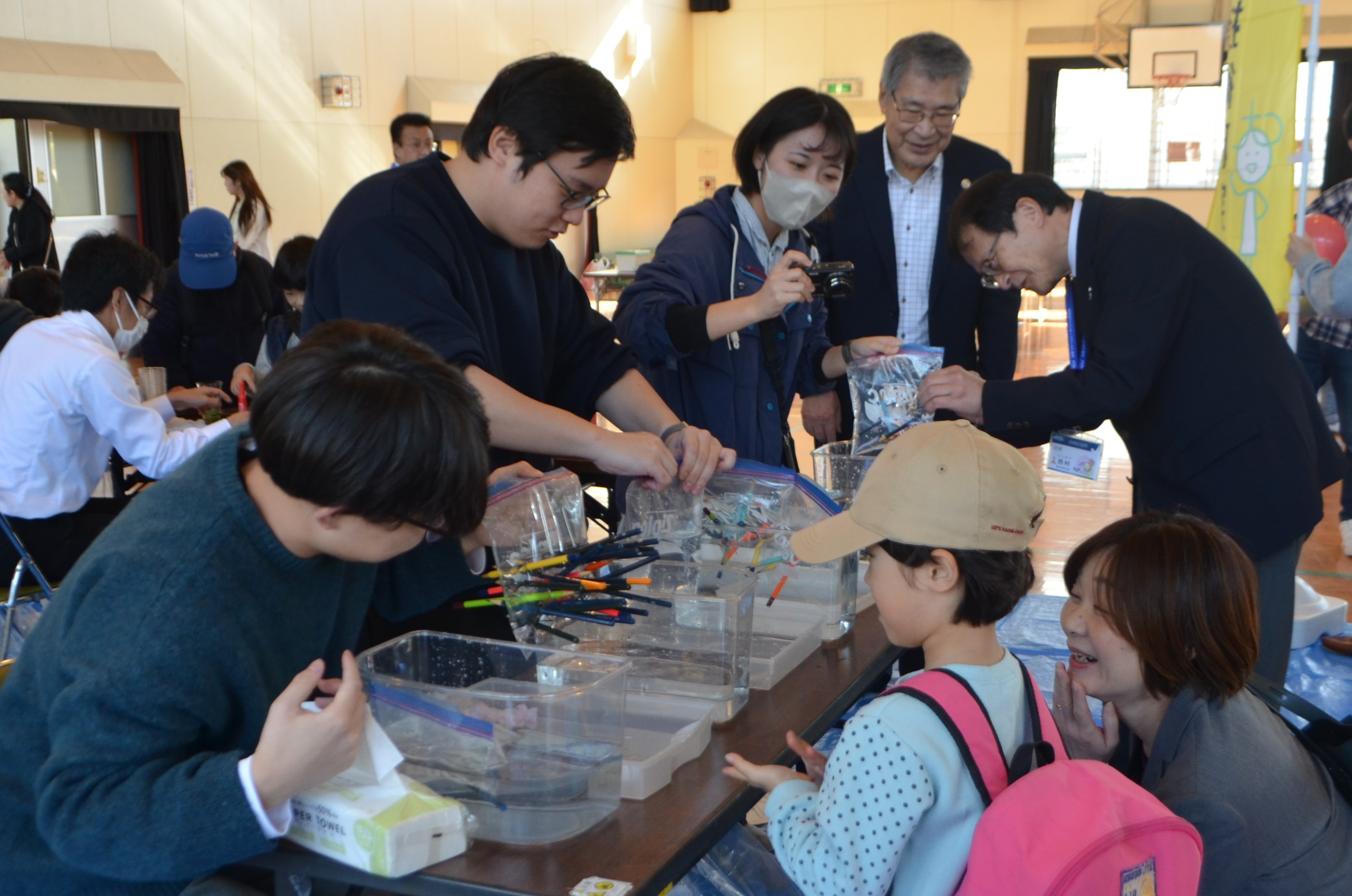 水を使った実験を体験する子どもと区長の写真