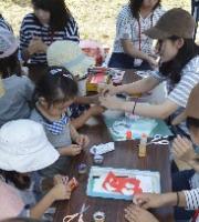 大学生と子どもたちが手作り工作をしている写真