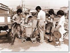 バケツに給水を受ける市民の写真