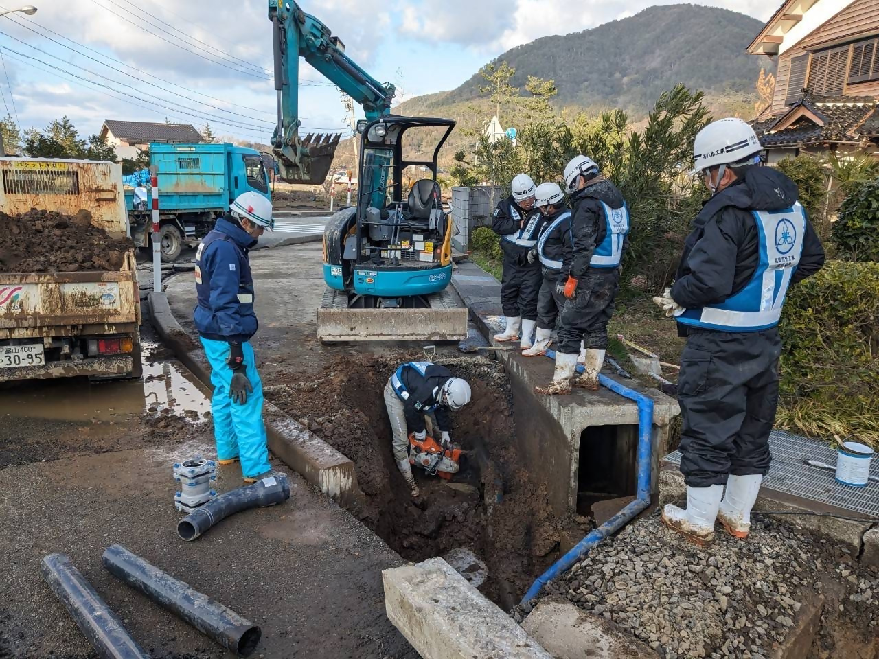 福岡市から派遣された応急復旧隊が道路上の破損した配水管を修理する様子