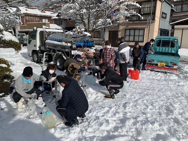 応急給水活動を行う福岡市職員と給水する住民