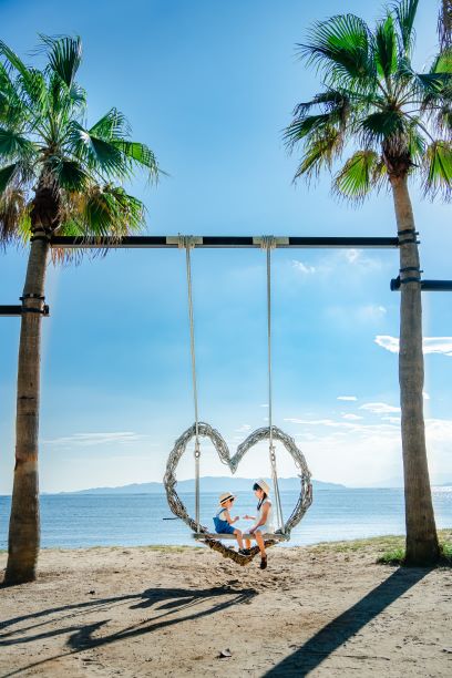 ざうおのヤシの木ブランコで遊ぶ子どもたちの写真