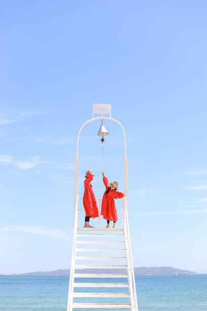 ざうお本店の鐘のオブジェを鳴らす姉妹