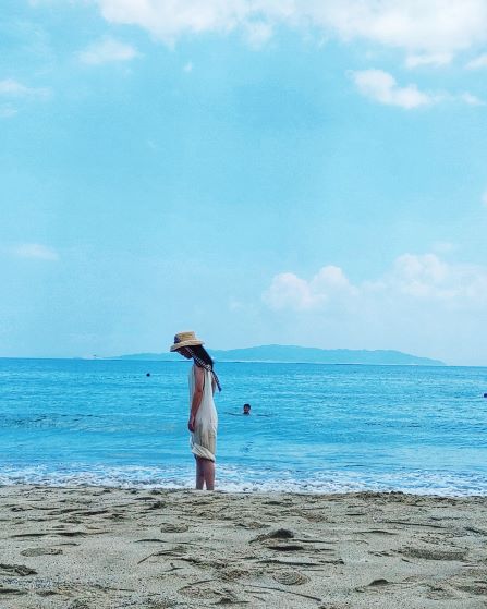 ざうお本店の海岸にたたずむ少女