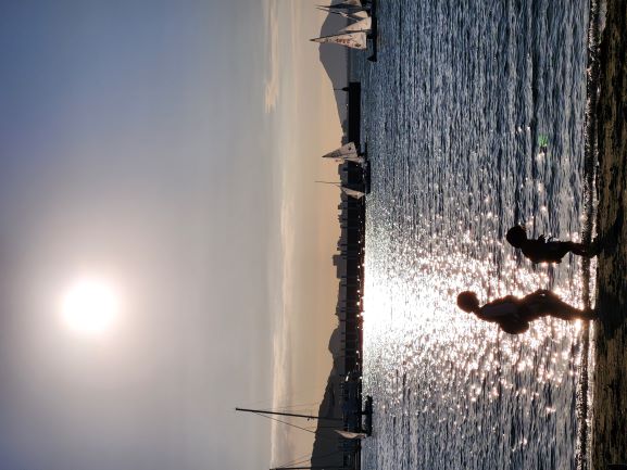 小戸公園の夕日をバックに親子が歩く写真