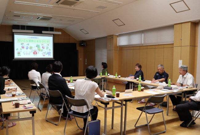 大きなスクリーンに映った紹介スライドを見ている様子