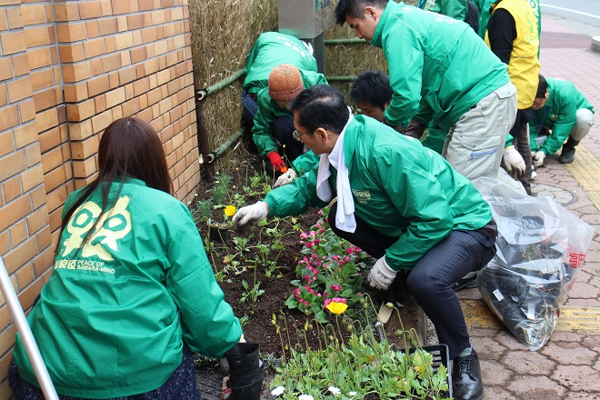地下鉄入り口前の花壇を植え替えている写真
