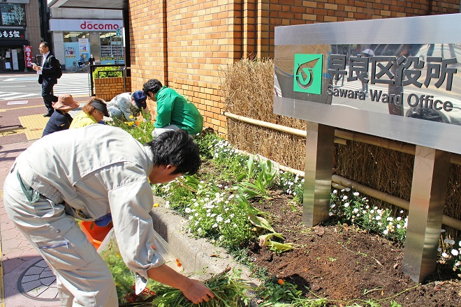 地下鉄藤崎駅入り口前の花壇の手入れをしている写真