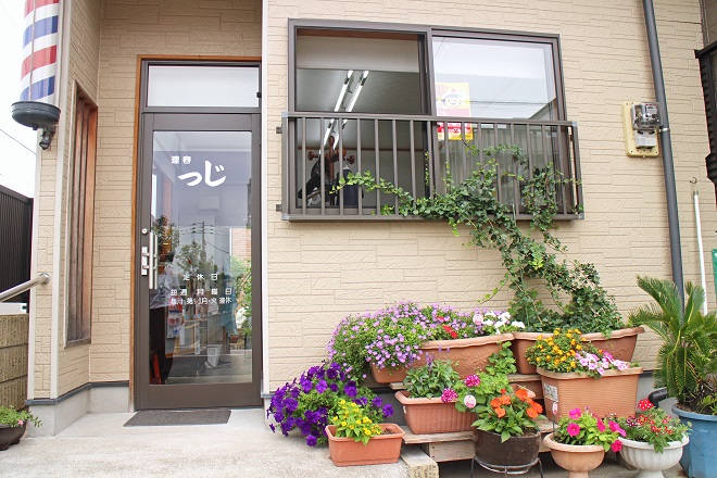 右下にたくさんのプランターが見える，「理容つじ」の写真