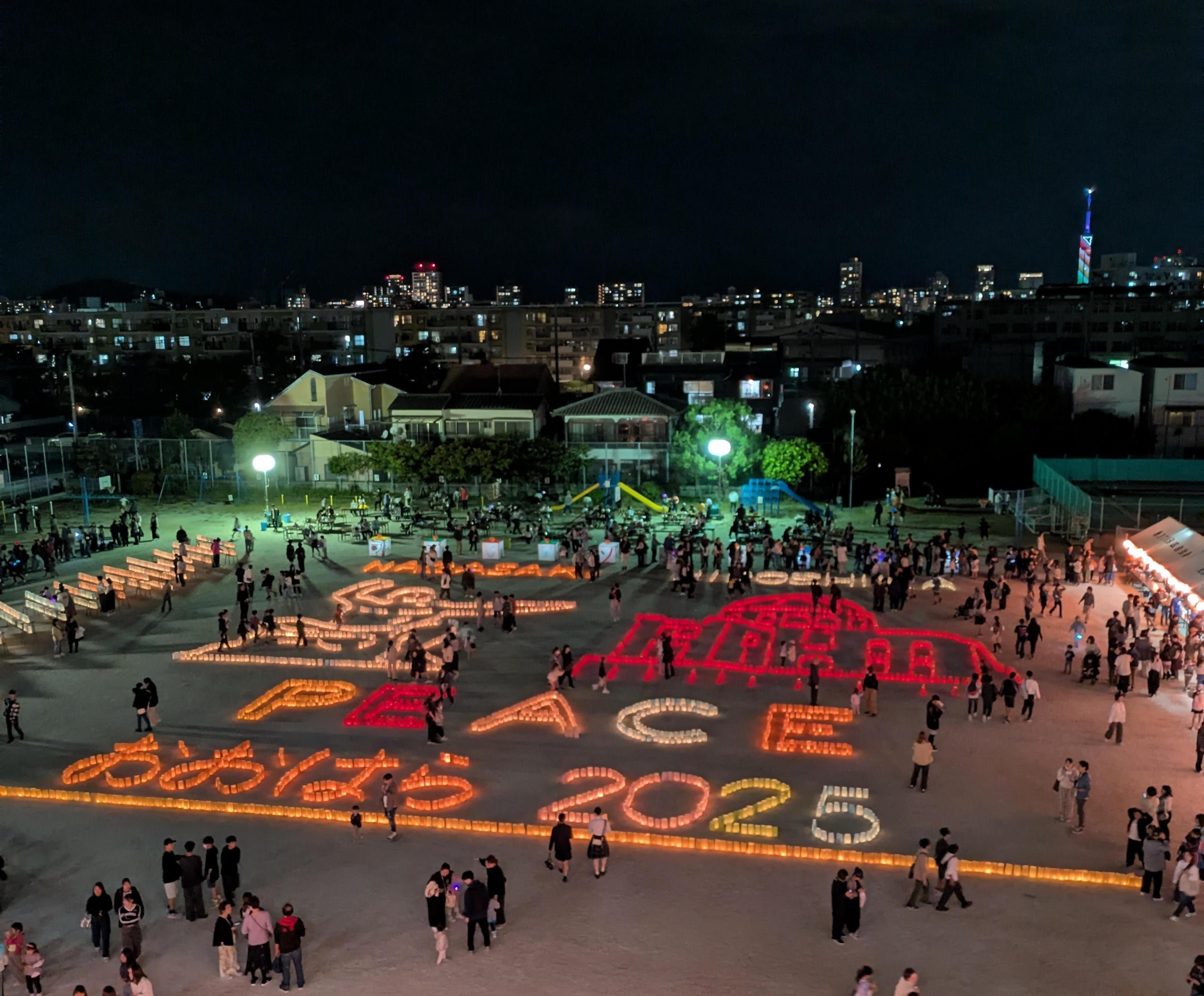小学校の校庭に描かれた灯明による長崎平和記念像と広島原爆ドーム