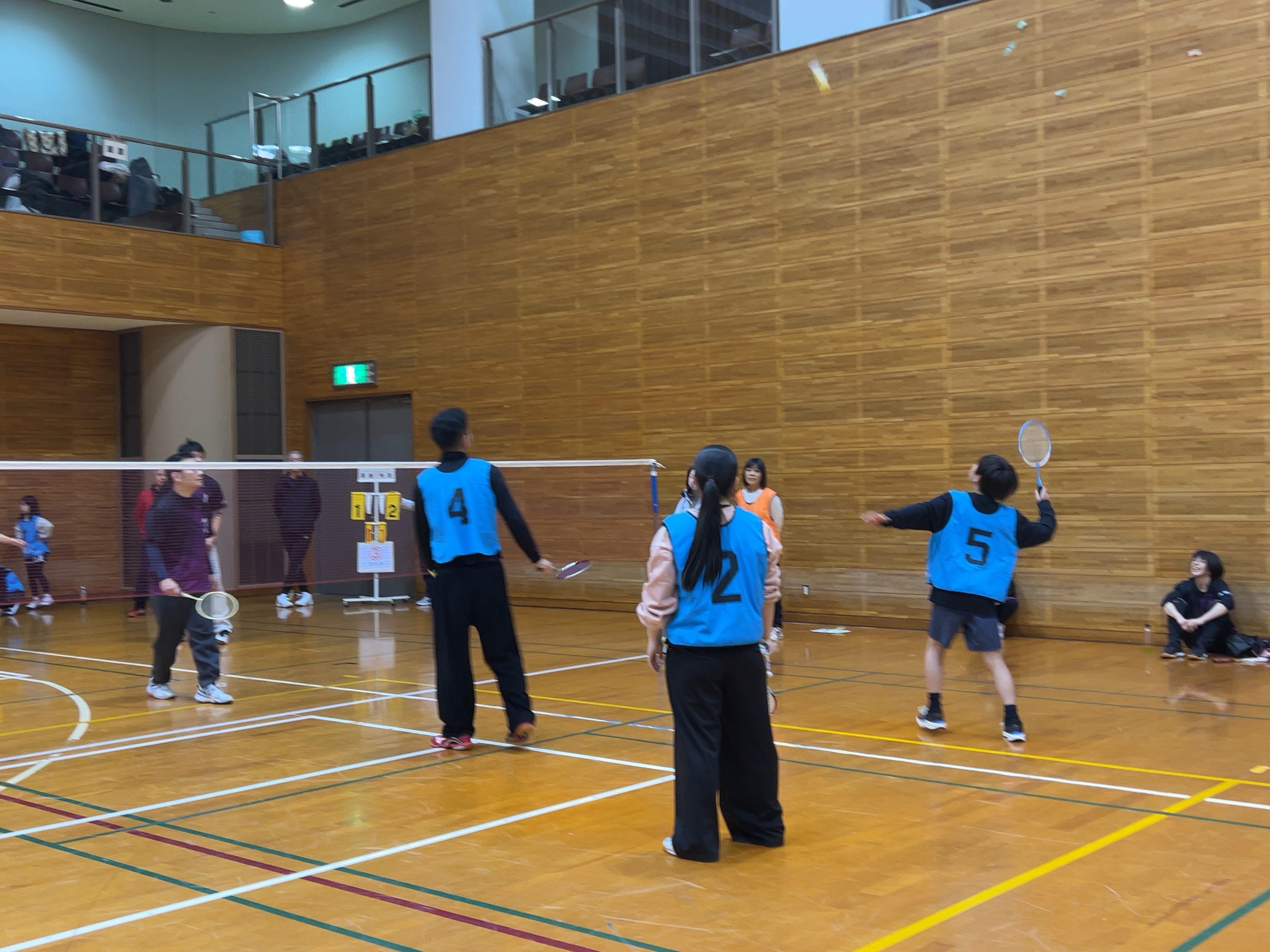 ファミリーバドミントンで羽根を打ち返す様子