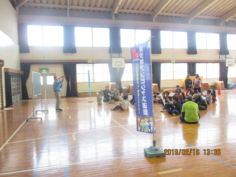 子どもたちに紙ヒコーキの折り方を説明する様子