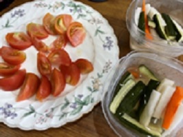 カットして皿に盛ったトマトや大根のピクルスなどの画像