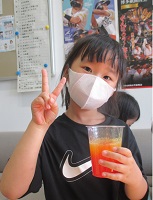 スライムを片手に持ちピースサインをする女の子の画像