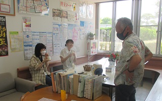 西南大学ボランティアの二人をねぎらう公民館館長の画像