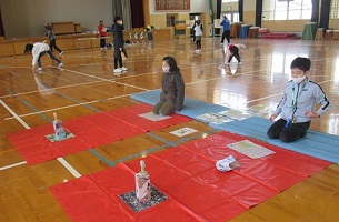 扇の要を持って姿勢を崩さずに蝶の的に投げます。