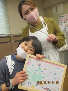 作品を持った子どもと講師の画像