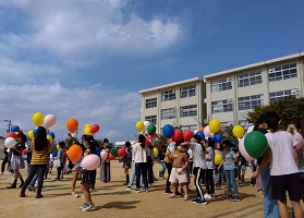 バルーンを空に飛ばすこどもたちの画像